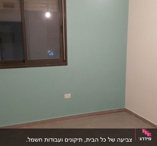 קיר צבוע בצבע תכלת עם חלון ונורה תלויה